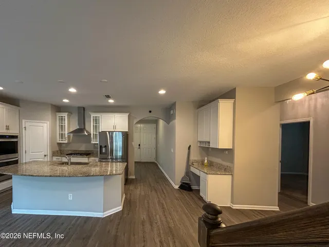 a view of kitchen with cabinets microwave and refrigerator