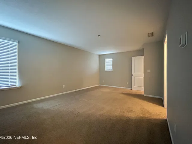 an empty room with windows and closet