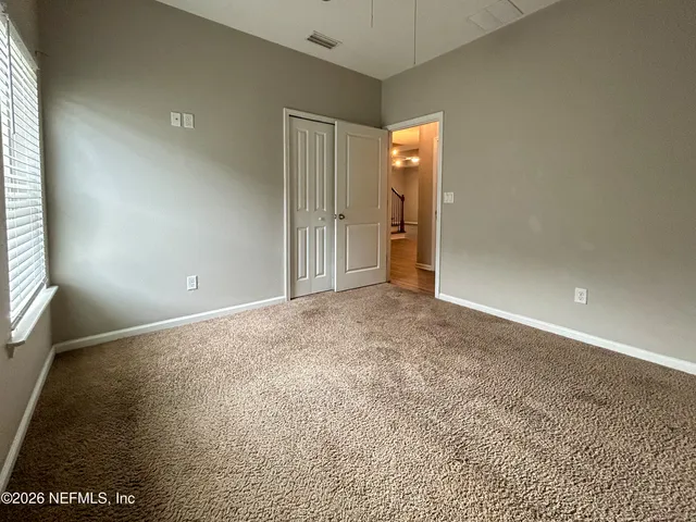 an empty room with a ceiling fan and window