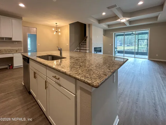 a kitchen with kitchen island granite countertop wooden cabinets and a granite counter tops