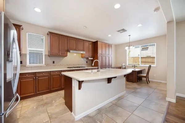 a kitchen with kitchen island granite countertop a sink counter top space appliances and a window