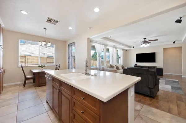 a large kitchen with kitchen island a sink table and chairs