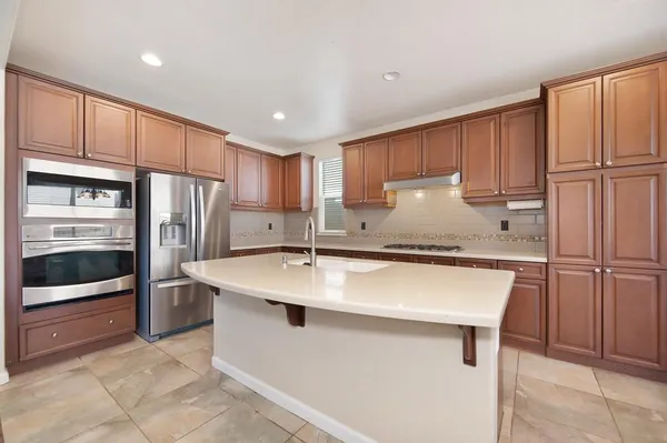 a kitchen with stainless steel appliances granite countertop a refrigerator sink and cabinets