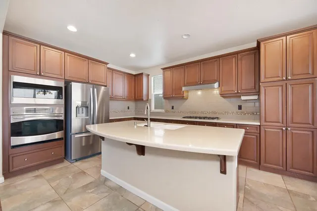 a kitchen with stainless steel appliances granite countertop a refrigerator sink and cabinets