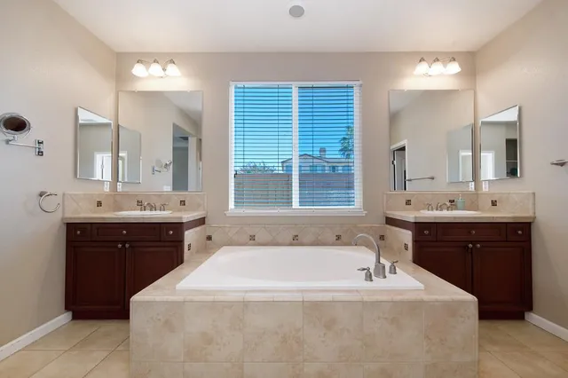a spacious bathroom with a tub sink and mirror