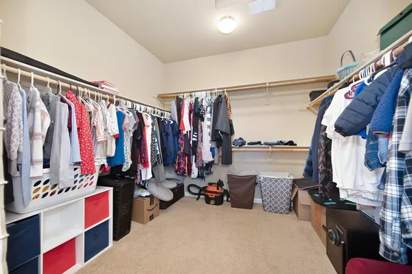 a view of walk in closet with clothes and shoes