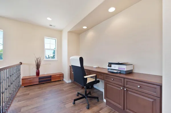 a view of a workspace with furniture and a window