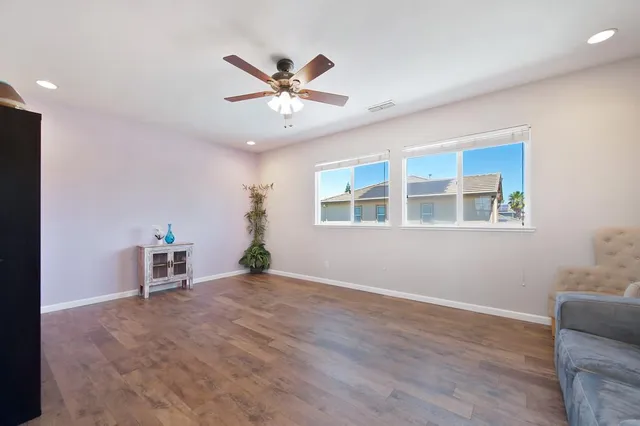 a view of a livingroom with a ceiling fan and window