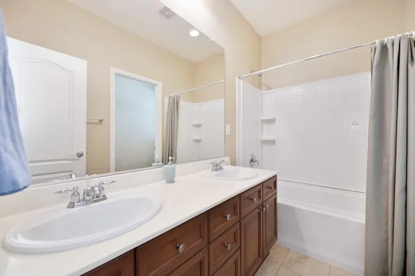 a bathroom with a double vanity sink mirror double and shower