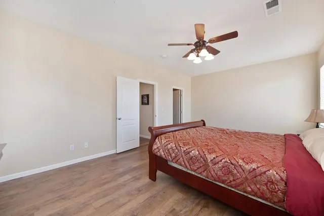 a bedroom with a bed and a ceiling fan