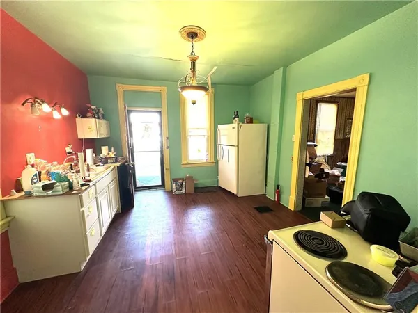 a kitchen with stainless steel appliances wooden floor and a refrigerator
