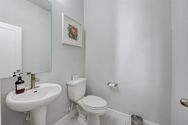 a bathroom with a sink toilet and a mirror