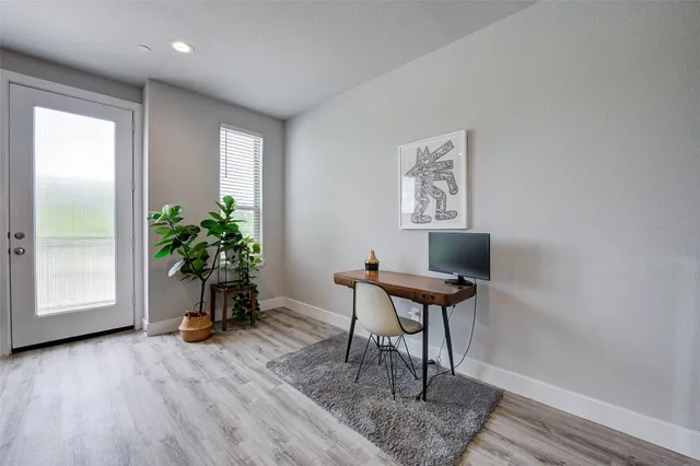 a view of a workspace with furniture and a window