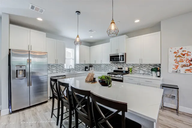 a kitchen with cabinets a center island stainless steel appliances and cabinets