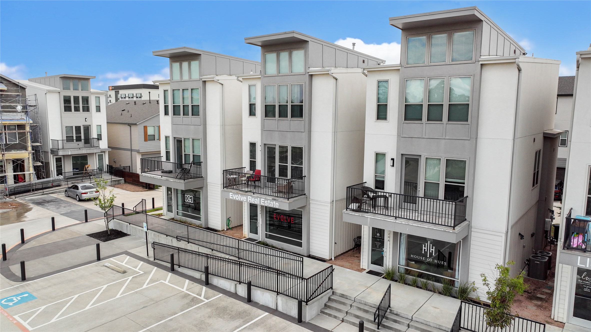18732 Centro Main Street, Unit B Shenandoah, TX 77385 - Photo 39 of 42 Modern townhouses with clean, contemporary architecture featuring three stories, large windows, and private balconies. The complex includes ground-level retail spaces and is situated in a well-maintained urban setting.