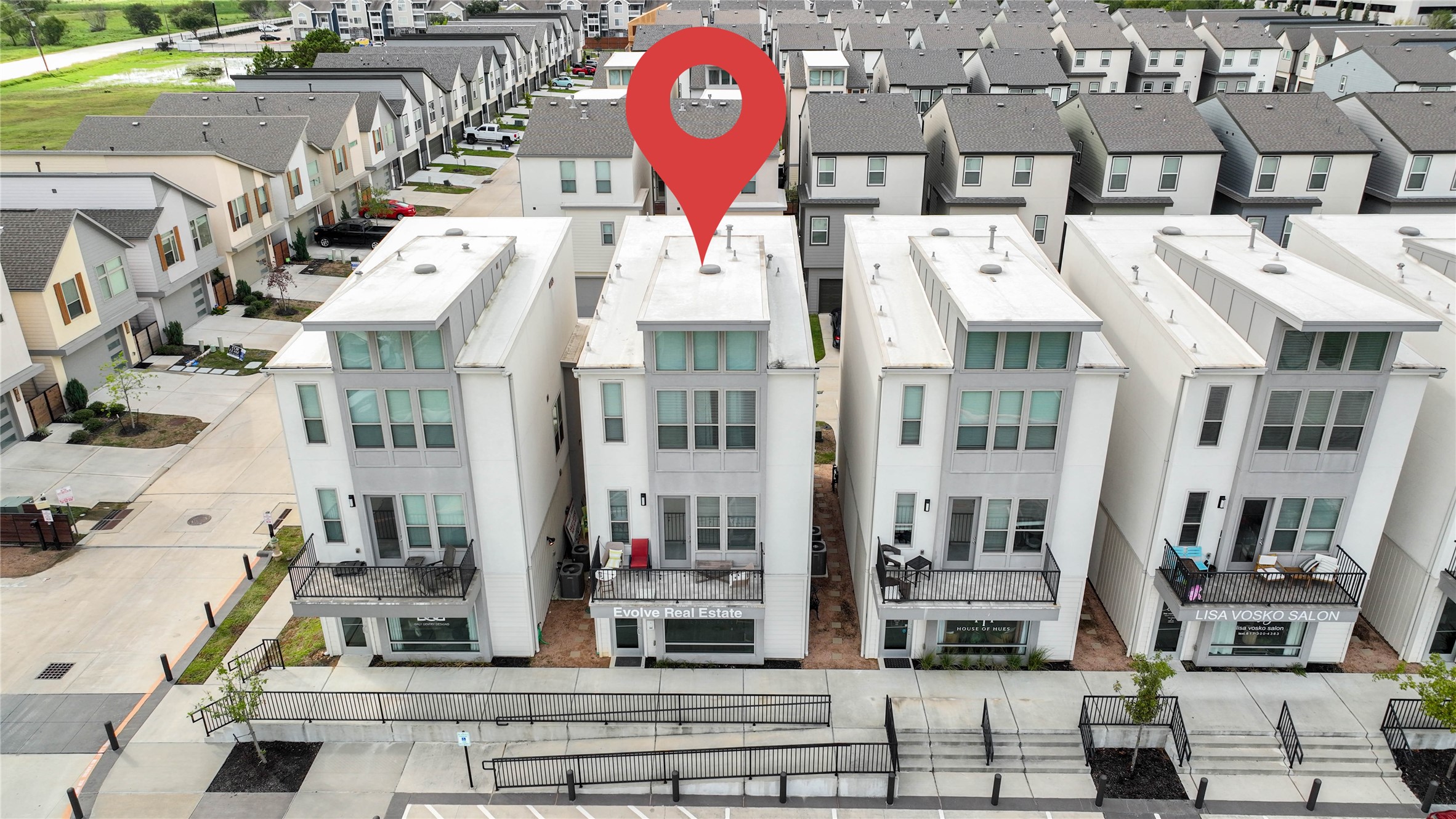 18732 Centro Main Street, Unit B Shenandoah, TX 77385 - Photo 40 of 42 Modern three-story townhouse in a well-organized, urban neighborhood. Features include large windows, balconies, and a clean, contemporary design. The area is neatly landscaped and has convenient access to nearby amenities.