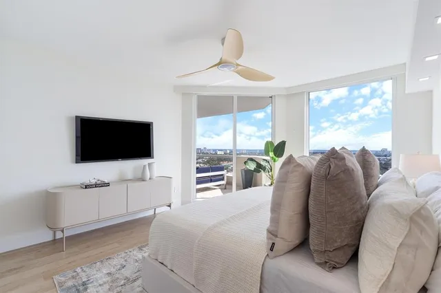 a spacious bedroom with a bed and a flat screen tv