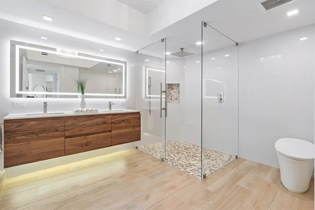 a bathroom with a granite countertop sink mirror vanity and toilet