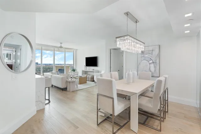 a view of a dining room with furniture a chandelier and wooden floor