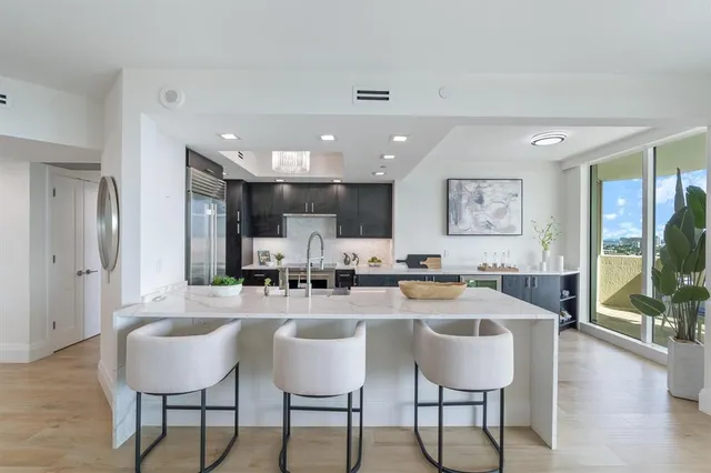 a kitchen with a dining table chairs and white cabinets
