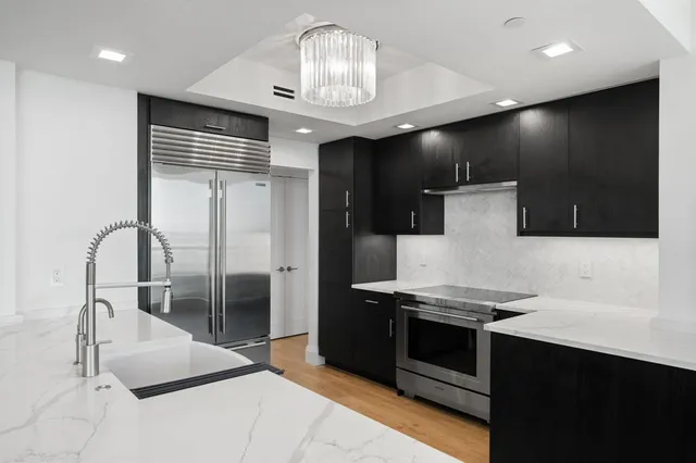 a kitchen with stainless steel appliances granite countertop a sink and a stove