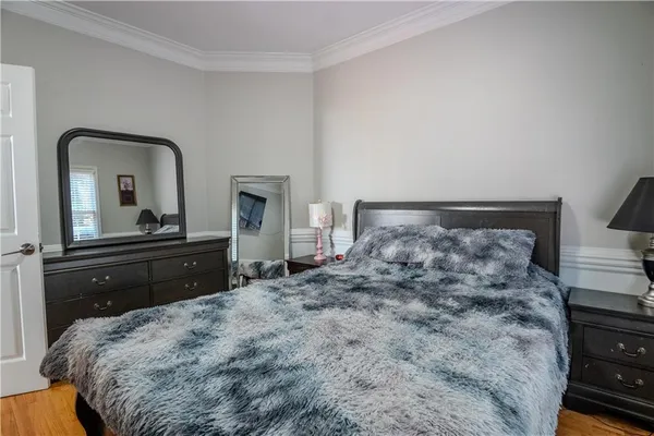 a bedroom with a bed and a dresser with mirror