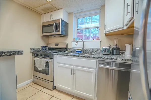 a kitchen with appliances a sink and cabinets