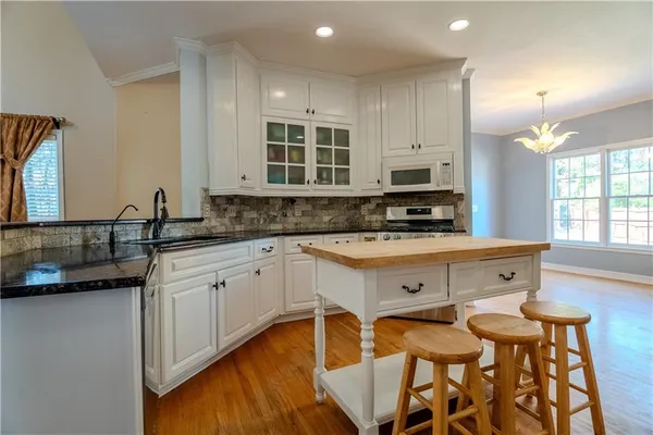 a kitchen with stainless steel appliances granite countertop a stove a sink dishwasher and a microwave oven with cabinets