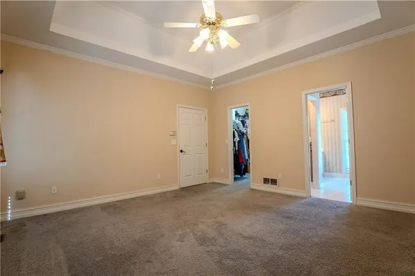 an empty room with closet and a chandelier fan