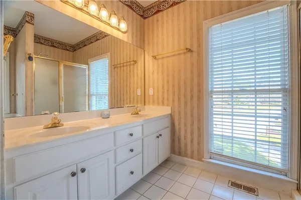a spacious bathroom with a double vanity sink mirror and a bathtub