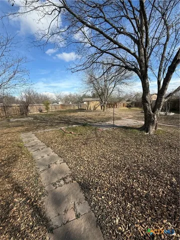 a view of a yard with wooden fence