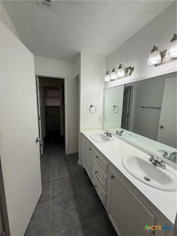 a spacious bathroom with a double vanity sink and a mirror