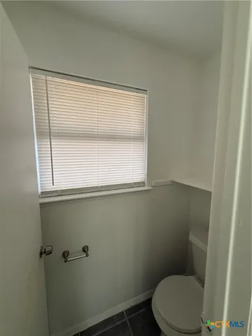 a toilet sitting in a bathroom next to a window
