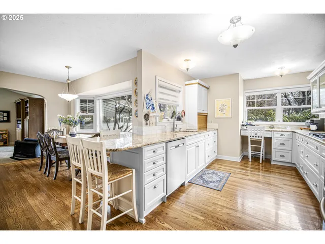 a large white kitchen with stainless steel appliances lots of white cabinets