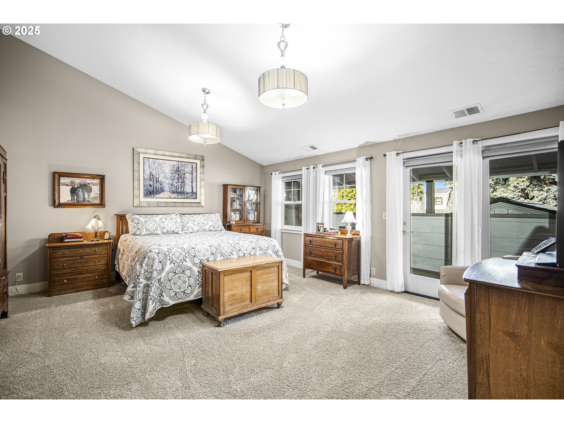 898 Northwest Riverside Boulevard Bend, OR 97703 - Photo 18 of 32 a spacious bedroom with a bed a dresser and paintings