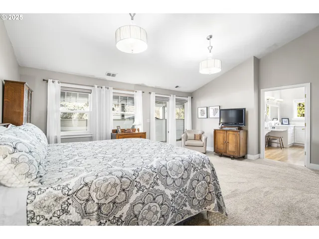 a bedroom with a large bed and a flat tv screen