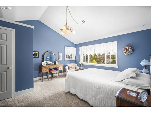 a bedroom with a bed mirror table and window