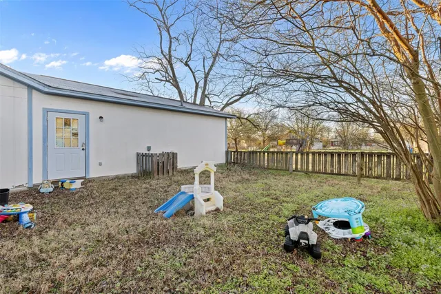a backyard of a house with table and chairs