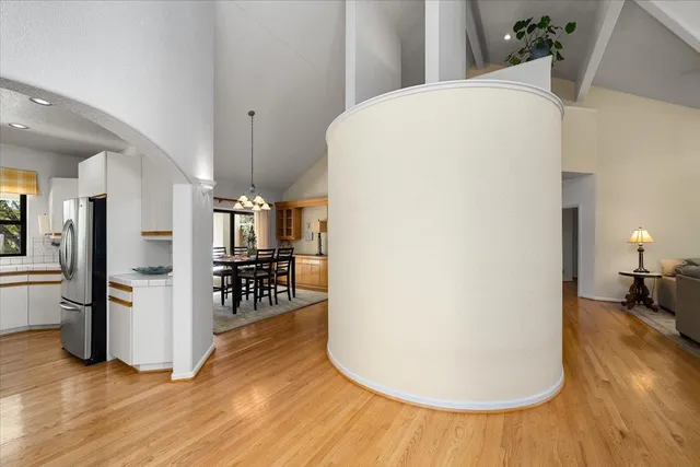 a dining room with wooden floor a chandelier a wooden table and chairs