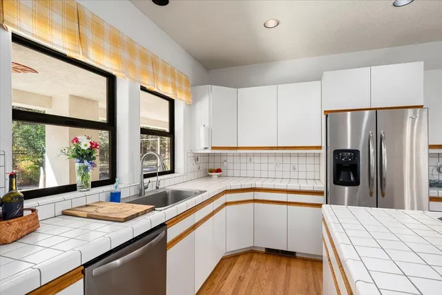 a living room with furniture large window and wooden floor
