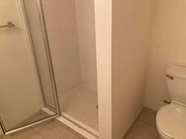 an empty room with a window and a chandelier fan