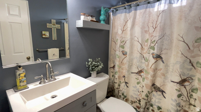 1797 Sunset Road Enoch, UT 84721 - Photo 29 of 80 Bathroom vanity featuring a white integrated sink with chrome faucet, a rectangular mirror, and gray cabinetry