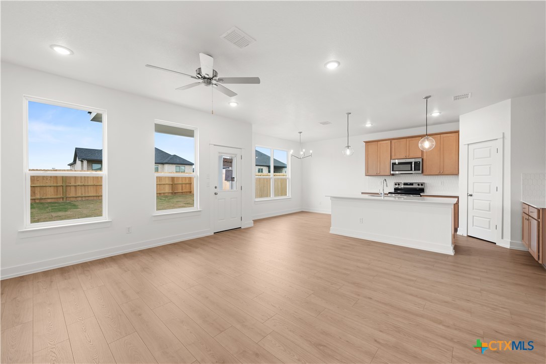 1218 Cilantro Road Temple, TX 76501 - Photo 7 of 16 a view of kitchen with kitchen island stainless steel appliances wooden floor and window