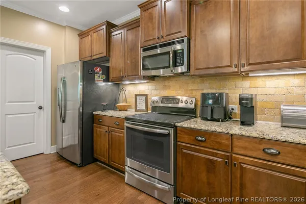a kitchen with stainless steel appliances granite countertop a stove a sink and a microwave