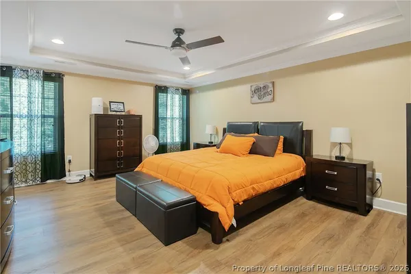 a spacious bedroom with a bed and a dresser with mirror
