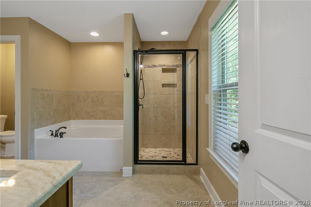 16 Spring Pond Lane Spring Lake, NC 28390 - Photo 15 of 33 a bathroom with a bathtub and a shower