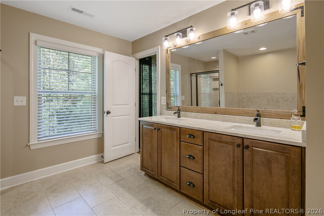 16 Spring Pond Lane Spring Lake, NC 28390 - Photo 16 of 33 a spacious bathroom with a double vanity sink a mirror and a bathtub