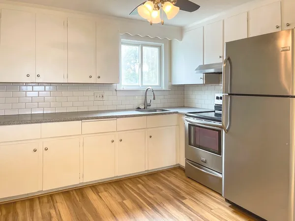 a kitchen with a refrigerator sink and cabinets