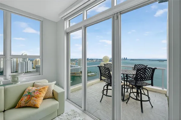 a living room with furniture and a floor to ceiling window