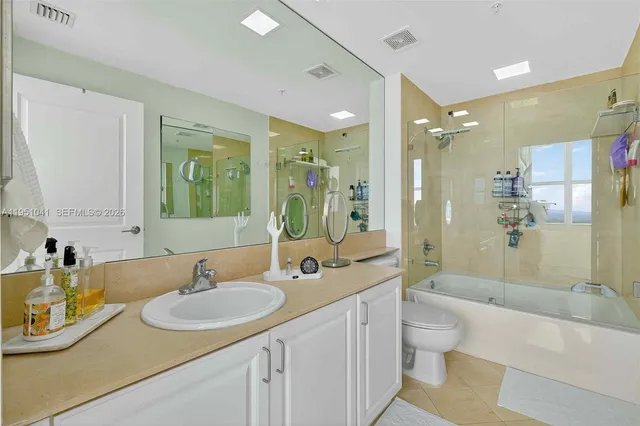 a bathroom with a sink double vanity granite tub shower and a mirror